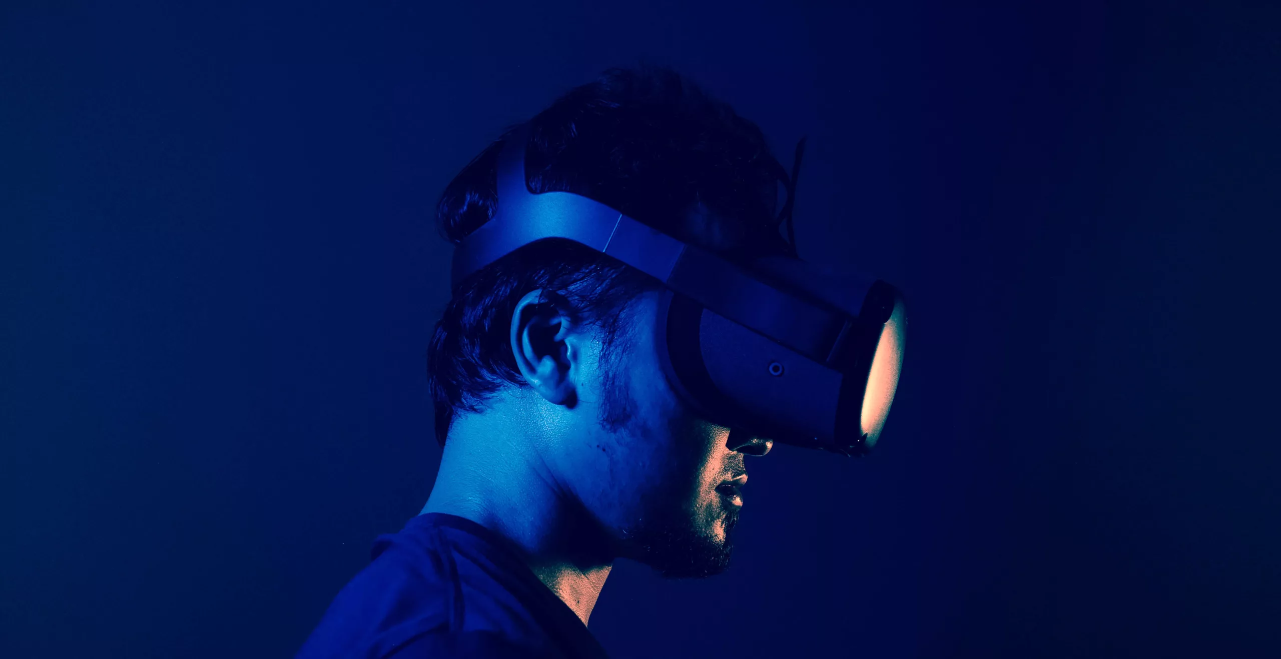 A man using a VR headset in a dark room